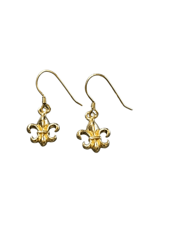 A pair of gold earrings with fleur de lis on them.